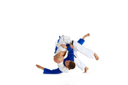 Photo for Two male professional sportsmen during match. Karate fighter attacking his opponent with leg technique isolated white background. Concept of martial art, combat sport, health, energy, fit. Copy space - Royalty Free Image