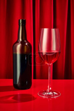Photo for Close up photo of sweet red, pink seasoned wine served in high glass classy and bottle of wine on bar counter at restaurant. Concept of night life, party time, holidays, Valentines Day, celebration - Royalty Free Image
