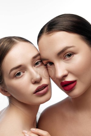 Téléchargez les photos : Portrait de mode de deux filles au maquillage naturel. Mettre l'accent sur une approche holistique de la santé et du bien-être par une peau claire et une beauté naturelle. Concept de jeunesse, soins de la peau, bien-être, spa. Publicité - en image libre de droit