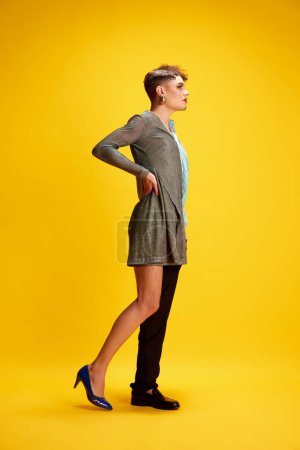 Photo for Side view full-length portrait of male model wearing half dress and smart casual attire posing against vivid yellow background. Concept of self-expression, fashion and style, beauty, lifestyle. Ad - Royalty Free Image