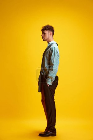 Photo for Side view full-length portrait of male model posing half-wearing as man and woman, exploring contemporary youth culture and gender identity. Concept of self-expression, fashion and style, lifestyle. - Royalty Free Image