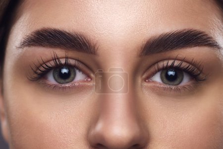 Ausgeschnittenes Porträt eines jungen attraktiven Mädchens mit glatter, frischer Haut. weibliches Gesicht, leuchtende Augen, lange Augenbrauen und Augenbrauen. Konzept der Anti-Aging-Hautpflege-Kosmetika, die empfindliche Augenpartie ansprechen.
