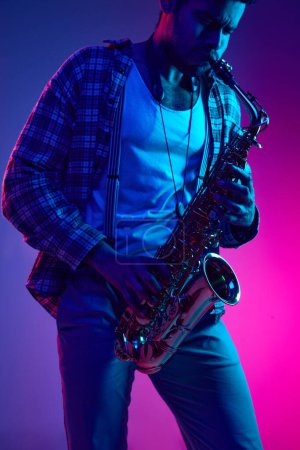 Téléchargez les photos : Saxophoniste virtuose, Afro-américain, artiste talentueux jouant de la mélodie sur fond bleu-rose dégradé. Concept de jazz, blues, musique instrumentale chic, festivals et concerts. Publicité - en image libre de droit