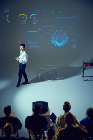 Photo for Technology seminar with Asian man presenter, speaker discussing complex data points in front of engaged audience. Concept of business, startup, leadership and personal development courses. - Royalty Free Image