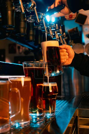 Taps pouring beer in pub, with variety of light and dark beer or ale glasses showcasing different brews. Serving craft beer from tap. Concept of alcohol drinks, nightlife, festivals, Oktoberfest. Ad