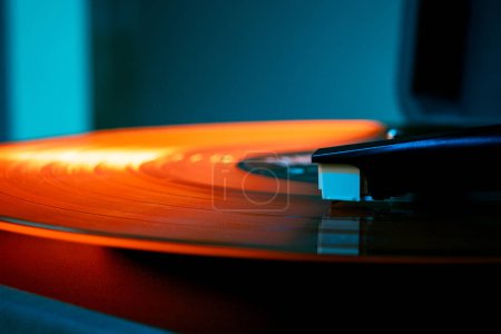 Foto de Foto detallada de la aguja del fonógrafo surgiendo olas de vinilos en tonos naranjas. Retro tocadiscos de vinilo, luces brillantes. Concepto de arte, música retro, disco, vintage, nostálgico, anticuado. Anuncio - Imagen libre de derechos
