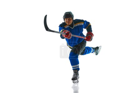 Photo for Committed hockey athlete showcases their mastery of attack and pass techniques against white studio background. Concept of professional sport, competition, movement, energy, tournament, match. Ad - Royalty Free Image