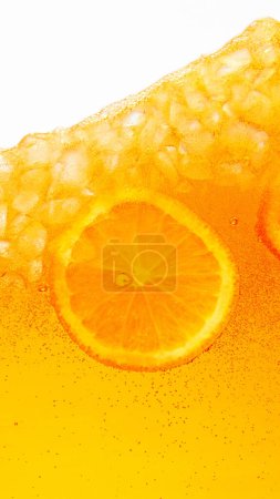 Close up photo of exotic drink with ice cubes and slices of sweet and sour citrus fruit, orange. Textured photo. Abstract wallpaper. Concept of food and drinks, summer,vitamins, nutrition, dieting. Ad