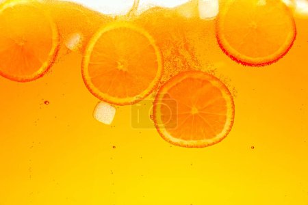 Textured photo. Playful bubbles cascade around plump orange slices in sparkling beverage. Abstract wallpaper. Concept of food and drinks, summer,vitamins, nutrition, refresh.