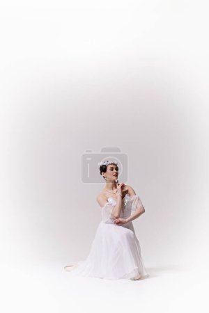 Cartel. Mujer joven, talentosa bailarina, vestida de blanco, demuestra elegancia y ternura contra el fondo blanco del estudio. Concepto de arte, fusión de clásico y modernidad, gracia y elegancia.