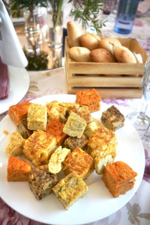 Fresh bread rolls in a wooden basket on a festively decorated table with omelets.