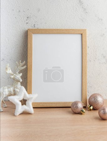 White blank wooden frame mockup with Christmas decorations  on the wooden table.  Frame for quotes. Christmas postcard