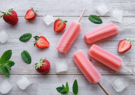 Téléchargez les photos : Glaces glacées aux fraises congelées maison et fraises fraîches sur fond de béton. Dessert d'été - en image libre de droit