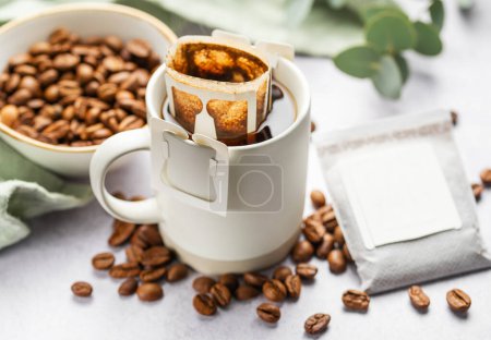 Foto de Goteo bolsa de café con café molido en taza. Hacer café recién hecho en casa. - Imagen libre de derechos
