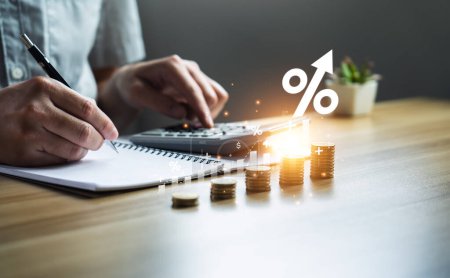 Photo for Interest rates and dividends, investment returns, income, retirement Compensation fund, dividend tax. pile of coins and upward direction percentage symbol. Businessman saving money for investment - Royalty Free Image