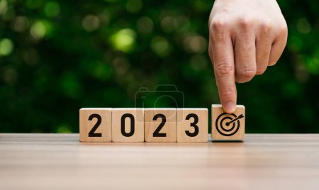 Foto de 2023 business ideas and market trends concept, goal, action plan, strategy, new year business vision. hand holding goal and cubes with text 2023. Development to success and motivation. target group - Imagen libre de derechos