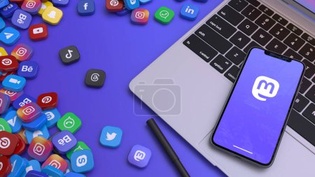 Photo for 3D rendering of a smart phone showing the icon of Mastodon on a laptop surrounded by the most important social networks' badges. - Royalty Free Image
