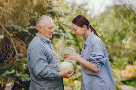 Photo for Senior with green gabbage. Brunette in a blue shirt. Grandfather with grandaughter. - Royalty Free Image