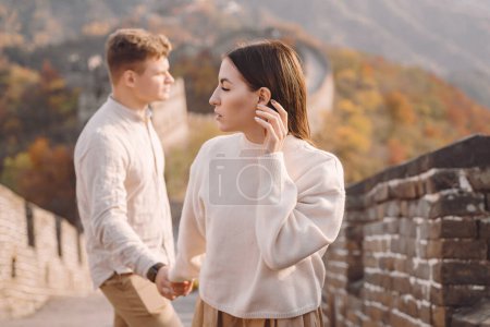 Foto de Hermosa pareja joven tomados de la mano y mostrando afecto en la Gran Muralla de China. Pareja recién casada en su honemoon a la Gran Muralla cerca de Beijing China. Elegante pareja explorando uno de los - Imagen libre de derechos