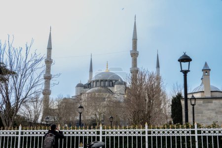 Foto de Los turistas caminan por la famosa Mezquita Azul en la zona de Sultanahmet de Estambul. La Mezquita Azul es una mezquita imperial histórica de la época otomana. Fue construido entre 1609 y 1616 durante el gobierno de Ahmed I.. - Imagen libre de derechos