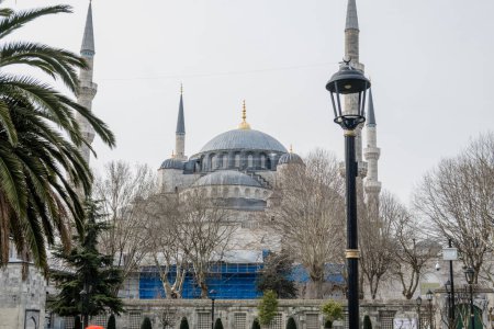 Téléchargez les photos : Les touristes marchent par la célèbre mosquée bleue dans la région de Sultanahmet d'Istanbul. La Mosquée Bleue est une mosquée impériale historique de l'époque ottomane. Il a été construit entre 1609 et 1616 sous le règne d'Ahmed Ier. - en image libre de droit