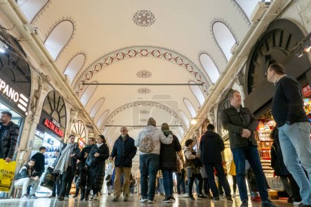 Téléchargez les photos : Les gens explorent le Grand Bazar d'Istanbul, l'un des plus grands et des plus anciens marchés couverts au monde, avec plus de 4000 boutiques réparties dans 61 rues couvertes. Les visiteurs peuvent se plonger dans un labyrinthe de textiles, bijoux, épices, céramiques, un - en image libre de droit