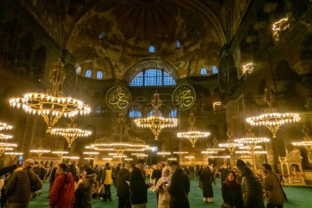 Téléchargez les photos : Les touristes et les habitants visitent Hagia Sophia, un magnifique chef-d'œuvre architectural situé à Istanbul, en Turquie, qui a servi d'église, de mosquée et de musée au cours des siècles. Avec son dôme planant, ses mosaïques complexes et sa riche histoire, il reste - en image libre de droit