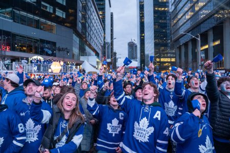 Foto de TORONTO, ONTARIO, CANADÁ - 20 DE ABRIL DE 2024: los aficionados se reúnen en Maple Leaf Square fuera de Scotiabank Arena para ver jugar fuera del juego en pantalla grande, partido de hockey de Toronto - Imagen libre de derechos