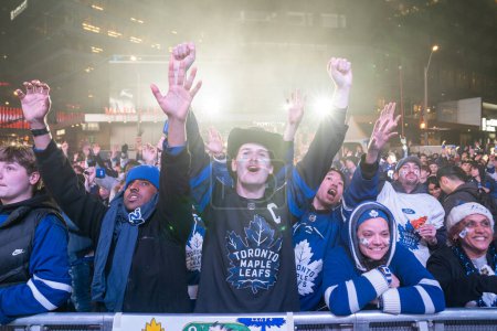 Foto de TORONTO, ONTARIO, CANADÁ - 20 DE ABRIL DE 2024: los aficionados se reúnen en Maple Leaf Square fuera de Scotiabank Arena para ver jugar fuera del juego en pantalla grande, partido de hockey de Toronto - Imagen libre de derechos
