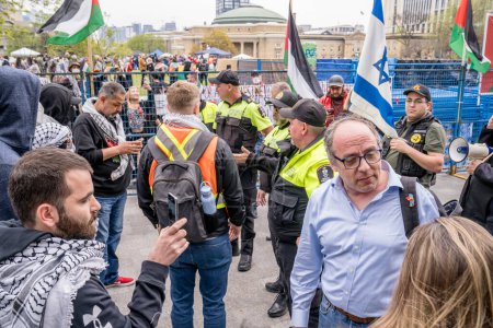 Foto de Manifestantes pro-palestinos y pro-israelíes fuera del campamento que los estudiantes crearon ocupando King College Circle en la Universidad de Toronto. - Imagen libre de derechos