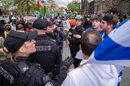 Téléchargez les photos : Canada, Toronto - 8 mai 2024 : des manifestants pro-palestiniens et pro-israéliens expriment passionnément leurs points de vue, avec des échanges intenses à l'extérieur du campement étudiant occupant le King's College Circle de l'Université de Toronto - en image libre de droit