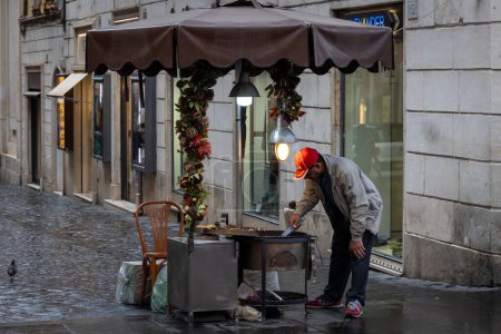 Foto de Roma, Italia - 7 de noviembre de 2023: Vendedor ambulante de castañas asadas con su puesto en el centro histórico de la ciudad. - Imagen libre de derechos
