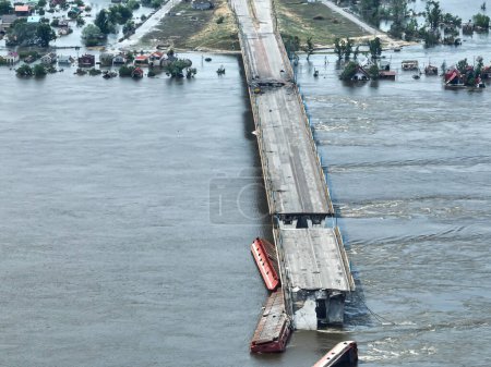 Foto de Destruyó el puente Antonovsky, ciudad de Kherson. Vista aérea superior del puente y el territorio ocupado. Grandes masas de agua se trasladan a la ciudad después de la explosión de la central hidroeléctrica - Imagen libre de derechos
