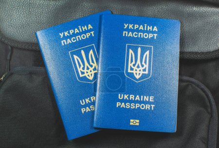 Photo for Ukrainian biometric passport id to travel the Europe without visas on the backpack. Inscription in Ukrainian "Ukraine Passport". Travel or migrants concept. - Royalty Free Image
