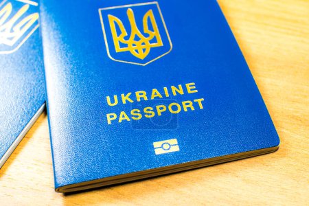 Foto de Ukrainian biometric passport id to travel the Europe without visas on the table. Inscription in Ukrainian "Ukraine Passport" - Imagen libre de derechos