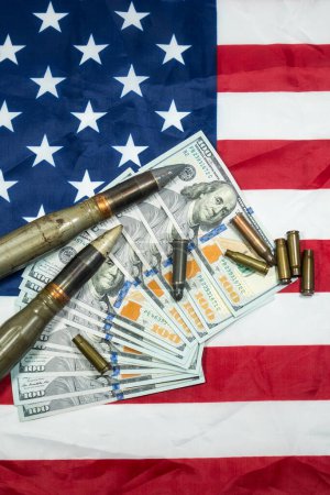 Foto de Bandera americana con dinero en dólares, balas, proyectiles, cartuchos y proyectiles. Concepto de Préstamo-Arriendo. Concepto del ejército. Venta de armas y municiones - Imagen libre de derechos