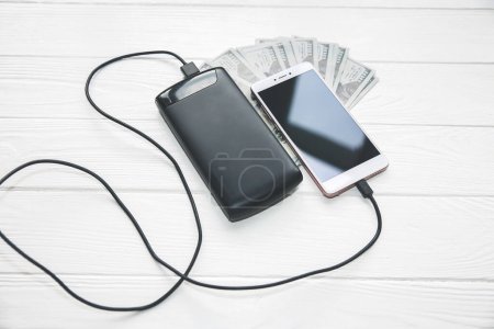 Photo for Power bank is charging mobile phone with usb cable - Royalty Free Image