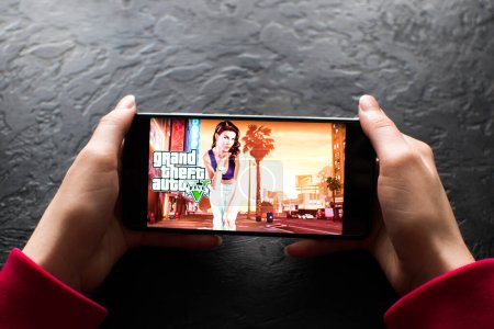 Photo for LVIV, UKRAINE - November 08, 2022 : Playing mobile game GTA V (Grand Theft Auto V) on modern smartphone. - Royalty Free Image