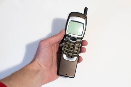 Téléchargez les photos : Vieux curseur de téléphone portable dans les mains de l'homme. Pastime, Technologie rétro. - en image libre de droit