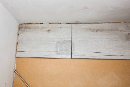 Foto de Suelo laminado en apartamento. Trabajos de reparación de mantenimiento en el piso. Renovación de tablones de parquet de madera en interiores. - Imagen libre de derechos