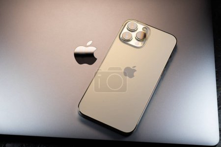 Foto de KYIV, UCRANIA - 20 de octubre de 2023: Smartphone moderno Apple iPhone 15 Pro y Apple Macbook Pro laptop. Gadgetes de tecnología Cupertino. Nombre del logotipo de marca. - Imagen libre de derechos