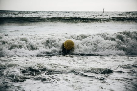 Foto de Boya en las olas del mar con espuma. Playa vacía. Viajes de vacaciones de verano. Océano tormentoso. - Imagen libre de derechos