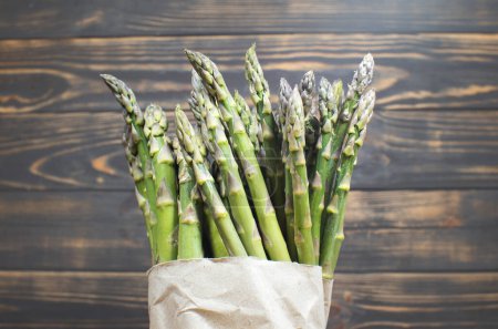 Green fresh bunch of a asparagus on wooden background. Healthy diet food. Vegetarian food.