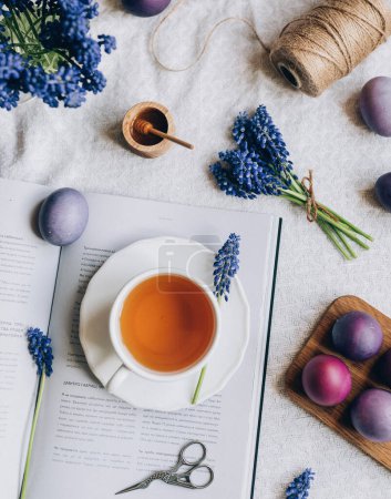 Foto de Vista superior de la composición de Pascua de huevos, taza de té, libro, flores - Imagen libre de derechos