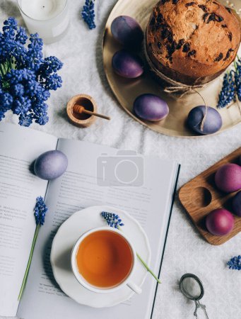 Photo for Top view of  Easter  composition of eggs, cup of tea, book, flowers, easter cake - Royalty Free Image