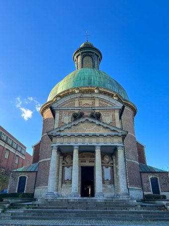 The neoclassical domed church stands tall, featuring grand design with vibrant green roof, majestic dome, and exquisite classical details that add charm and elegance. Church of Saint Joseph, Waterloo.