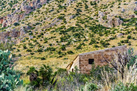 Foto de Pequeña casa de campo abandonada oculta, en las laderas de la montaña en Sicilia. - Imagen libre de derechos