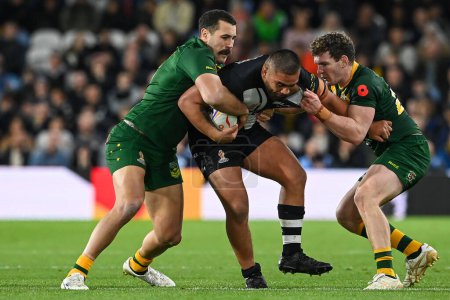 Photo for Isaiah Papali'i of New Zealand is tackled by Liam Martin and Reagan Campbell-Gillard of Australia during the Rugby League World Cup 2021 Semi Final match Australia vs New Zealand at Elland Road, Leeds, United Kingdom, 11th November 202 - Royalty Free Image