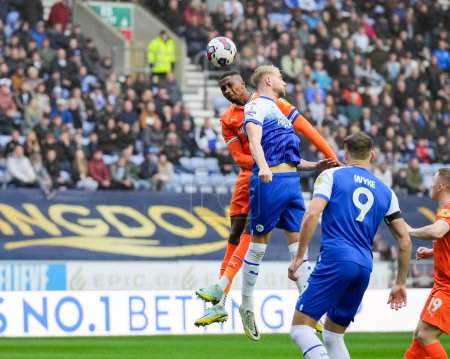 Photo for Marvin Ekpiteta #21 of Blackpool competes for a header with Jack Whatmough #5 of Wigan Athletic during the Sky Bet Championship match Wigan Athletic vs Blackpool at DW Stadium, Wigan, United Kingdom, 12th November 202 - Royalty Free Image
