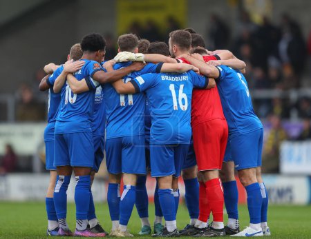 Photo for Chippenham Town players form a huddle during the Emirates FA Cup Round 2 match Burton Albion vs Chippenham Town at Pirelli Stadium, Burton upon Trent, United Kingdom, 27th November 2022 - Royalty Free Image